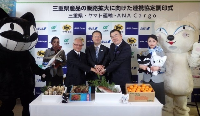 調印式のようす。左からヤマト運輸のキャラクター「クロネコ」、ANA客室乗務員、ANA Cargoの岡田社長、三重県の鈴木知事、ヤマト運輸の長尾社長、ANA客室乗務員、ヤマト運輸のキャラクター「シロネコ」
