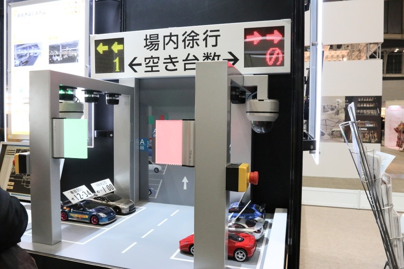 模型を使った監視カメラと各種センサーによる駐車場管制システムの利用イメージ。車番認識で特定車両の位置を特定し、センサーで満空情報を収集することで、混雑緩和や快適性を提供（撮影：防犯システム取材班）