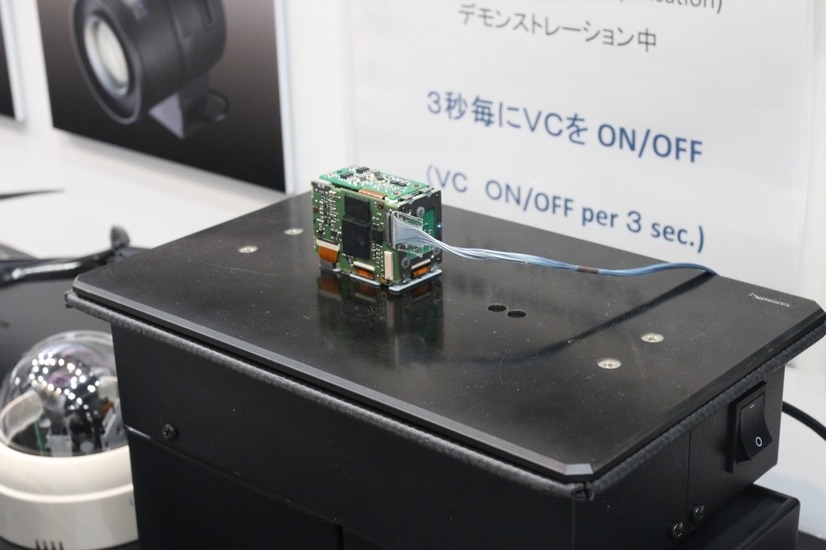 光学防振機構を搭載した超小型カメラモジュール「MP1010M-VC」を使ったデモの様子。黒い台は常に微振動を繰り返している（撮影：防犯システム取材班）