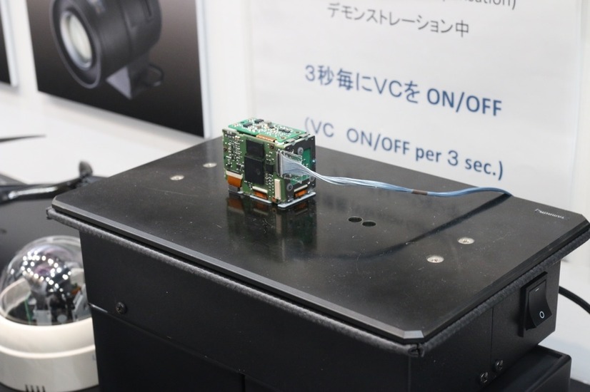 光学防振機構を搭載した超小型カメラモジュール「MP1010M-VC」を使ったデモの様子。黒い台は常に微振動を繰り返している（撮影：防犯システム取材班）