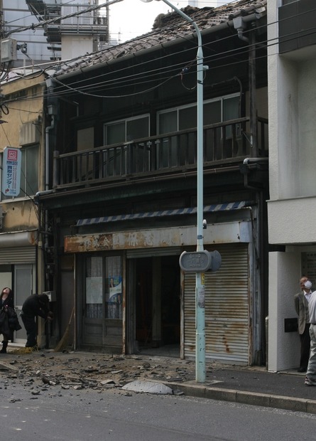 大きな揺れで瓦屋根が崩れ落ちた筆者の勤務先近くの家屋。幸いけが人はでなかったが、歩道が通れなくなったことで歩行者が車道に出るようになり、ちょっとした渋滞が起きていた（撮影：防犯システム取材班）