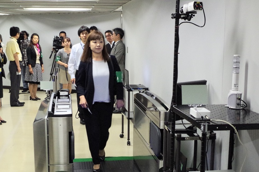 成田空港の従業員通路で行われた実証実験のひとコマ。従業員用IDカードをゲートにかざす際に爆発物の微粒子を採取し、顔認証システムで“なりすまし”でないかをチェックする（撮影：防犯システム取材班）