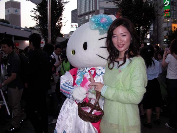 キティーちゃんと一緒にグッズを配る平松愛理さん