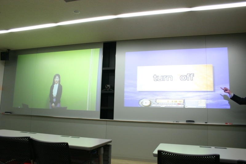 セミナールームの正面：2面のスクリーンパネルはホワイトボードのように使うことができる。真ん中にカメラが設置される