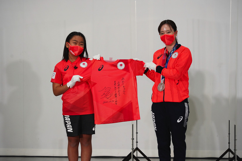 エスコートキッズにサイン入り「TEAM RED T シャツ」をプレゼントする石川佳純選手