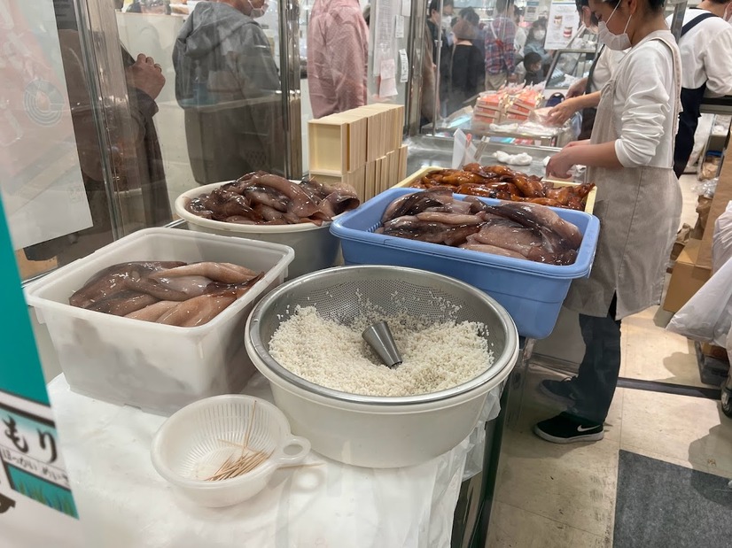 その場でイカに米を入れ、煮込み、折詰めするまでの全工程を行う