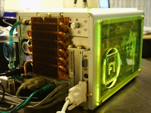 緑の蛍光色に光るキューブPC。背面には水冷型と思われる冷却装置がつけられている
