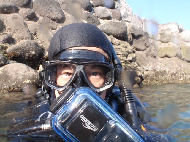 実際にiDive 300を装着して潜ってみた。写真ではわかりづらいが、マスク（ダイビング用ゴーグル）のストラップにヘッドホン（スピーカ）を固定している。本体はBCD（ダイビング用浮力調整ベスト）のDリングにストラップで固定できるので、ダイビング時に邪魔にならない。