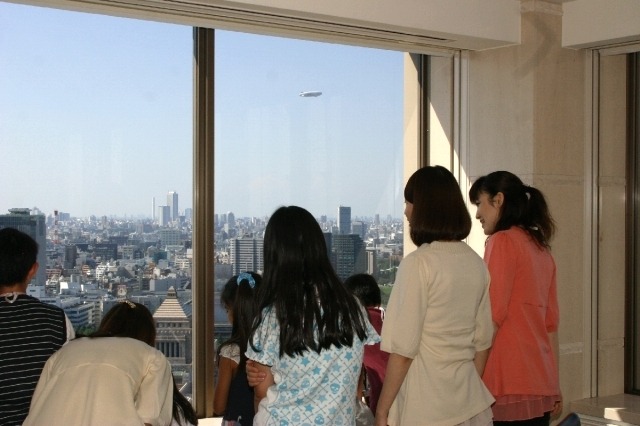 景色を眺める参加者たち。上空には宣伝用の飛行船が飛んでいた