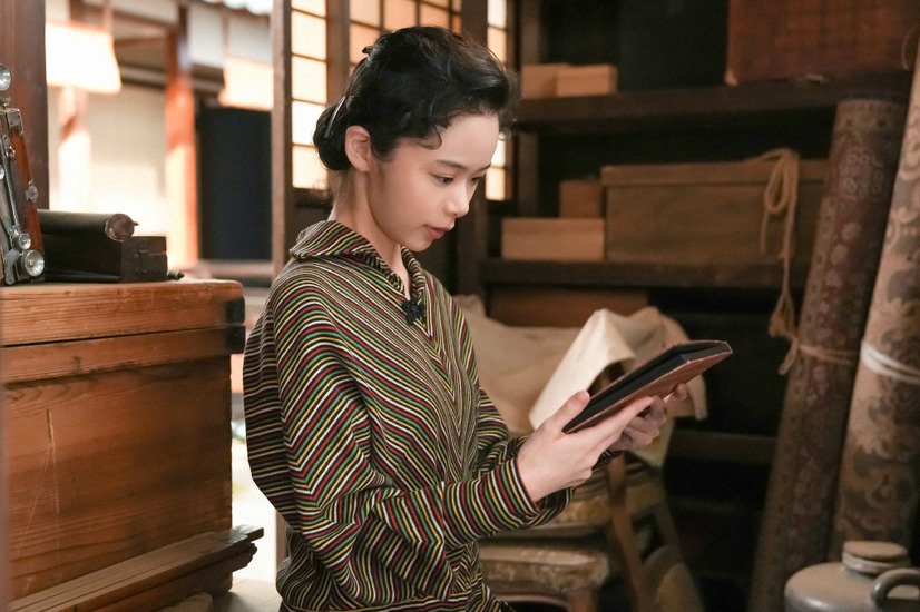 松吉の家・離れの倉庫にて。古いアルバムを手に取る福来スズ子（趣里）。  『ブギウギ』第108話（ｃ）NHK