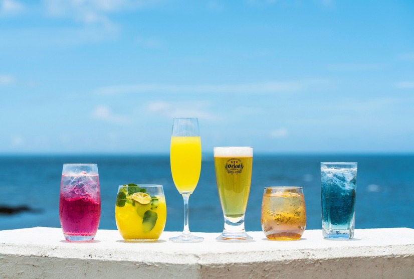 ドリンク左から【カフェンチュ】「WATTA パッションフルーツ カフェンチュオリジナルアレンジ『北谷サンセット』」801円（1杯）【オッチサイダリー】「occi シークヮーサーノンアルモヒート」 イートイン 880円（1杯）、「occi シークヮーサースパークリングワイン」 イートイン 990円（1杯）【オリオンビール】「オリオン生ビール」 601円（1杯）【カフェンチュ】「ルートビアシュナップス」 801円（1杯）、「WATTA 雪塩シークヮーサー カフェンチュオリジナルアレンジ『青の洞窟』」801円（1杯）