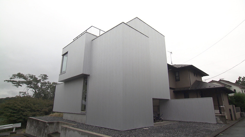 シルバーのガルバリウム鋼板に覆われ、窓が１つもない正面側の外観©MBS