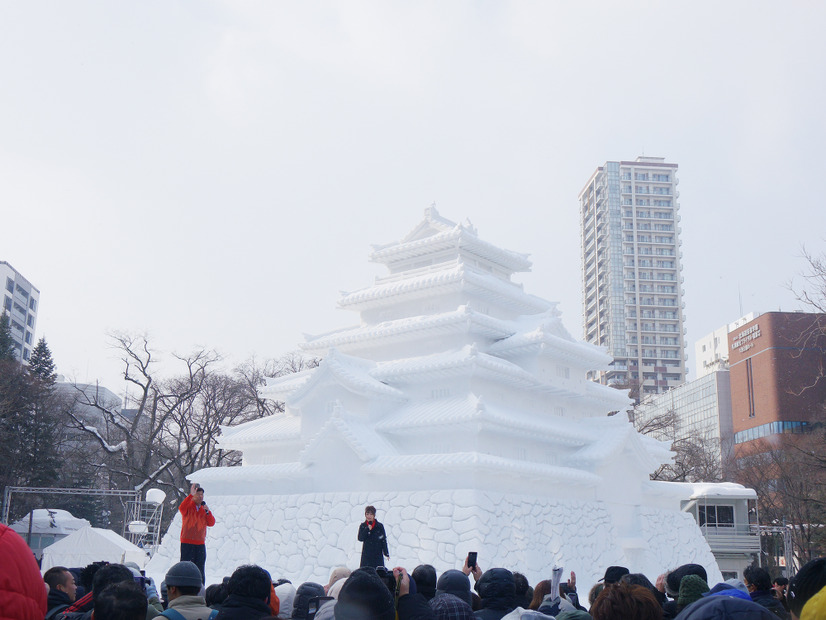 会津鶴ヶ城の巨大雪像のステージ（（ｃ）HTB）。夢グループ石田重廣社長と保科有里のステージに人だかり。【撮影：編集部】
