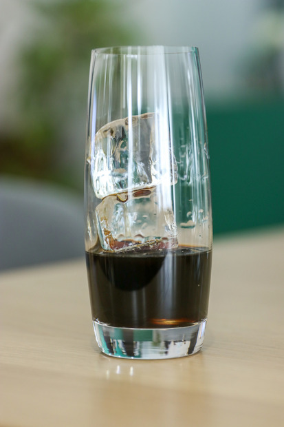 氷の入ったグラスにキャラメルフレーバーのコーヒークラフトを注ぐ【撮影／平木昌宏】