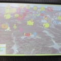 実際にPC上では写真のように見える。花粉のキャラクターとGoogle Earthの地域映像が合成されて表示。花粉キャラクターだけでなく、東京では東京タワーが見えたり、沖縄では守礼門が見えたりする