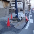 傾いた街灯を土嚢で抑える