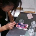 スマートフォンカバーにデコレーションを施すJeweluna・岡部真依氏