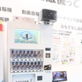 日本マシンサービスのブースに展示されていた「防犯自販機」。上部にあるボックスの中にネットワークカメラが内蔵されている。他にも防災用途を想定したサイネージ付きの自販機なども展示されていた（撮影：編集部）