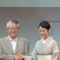 松下電器産業代表取締役副社長・牛丸俊三氏（左）と握手を交わす樋口さん