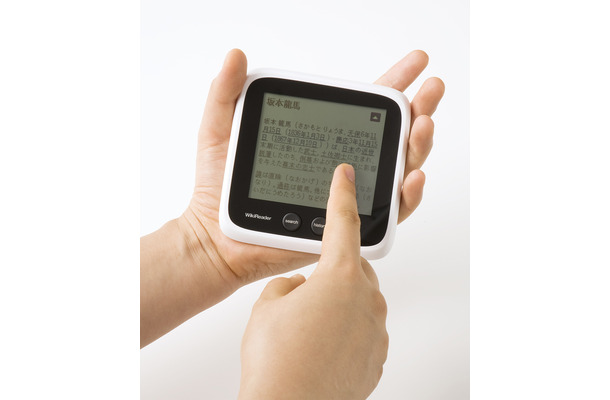 「WikiReader（ウィキリーダー） 日本語版」（型番：BWR-01）の手のひらサイズでタッチ操作のイメージ