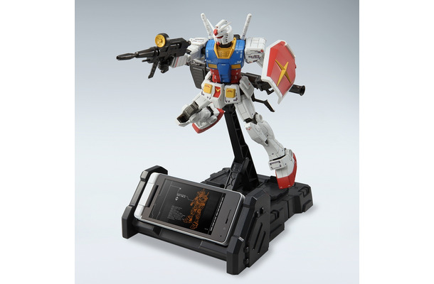 「945SH G Ver.GP30th」と充電台にセットされたガンプラ