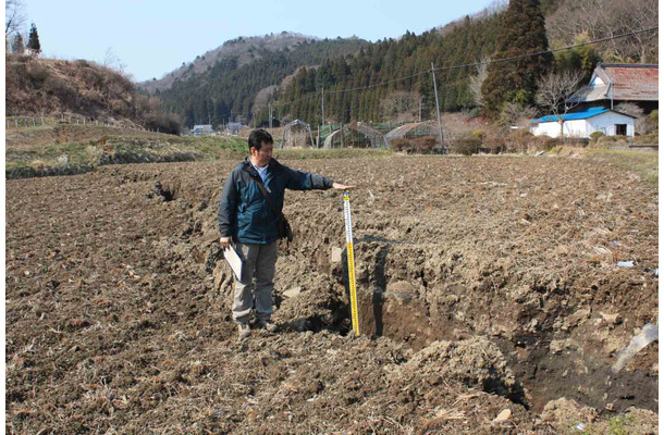  いわき市遠野町綱木，谷底面の水田を切る地表地震断層。北北西を望む。ほぼ垂直な断層面が開口亀裂に沿って露出する。（東京大学地震研究所）