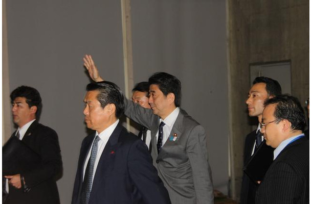 手を振りながら会場に入る安倍首相