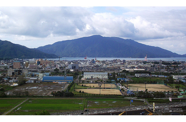 北陸道側から見た敦賀市街。手前の道路が国道8号（敦賀バイパス）、野球場がきらめきスタジアム。敦賀港の向こうに原発などが建つ敦賀半島が見える