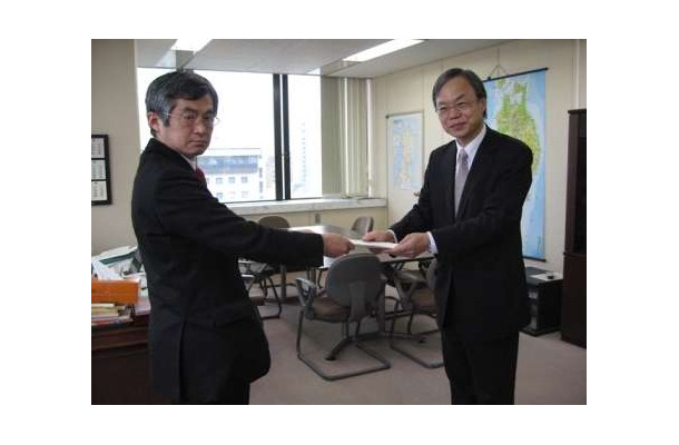 井澤一朗 総務省 東北総合通信局長（左）から免許状を受領する有田雅紀UQコミュニケーションズ 副社長（右）