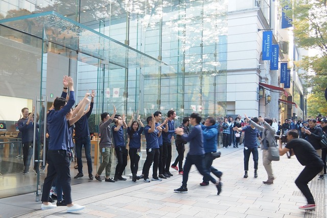 開店時間を迎え、ハイタッチで客を出迎えるアップルストアのスタッフたち