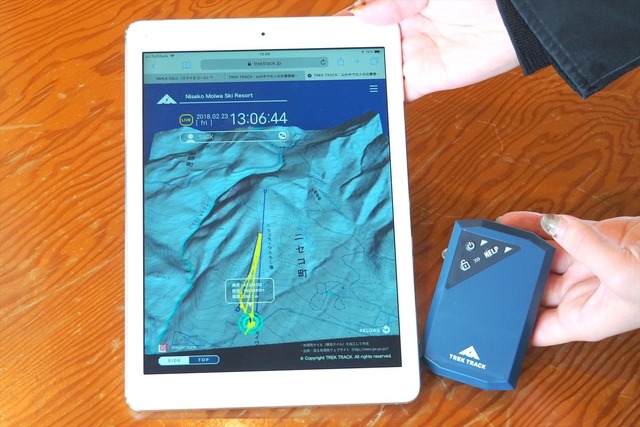手のひらサイズのIoTデバイス「TREK TRACK」（右側の青い端末）。スマホやタブレットから現在地が正確に把握できるほか、自身が滑走した軌跡なども記録できる