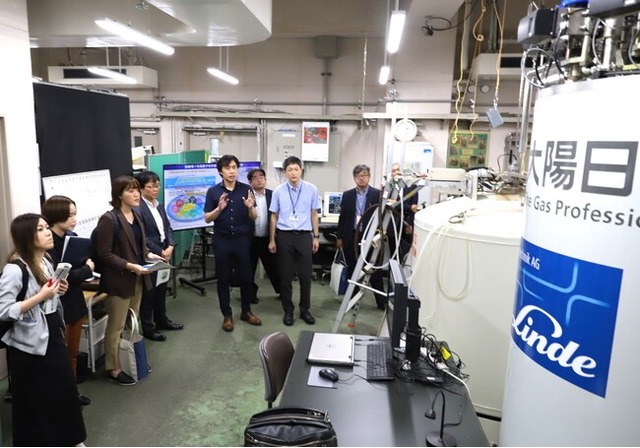 本学のヘリウム供給について説明する笠原教授(左から5人目)